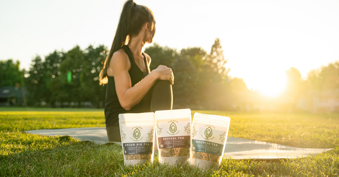 Woman doing yoga during the sunset with loose leaf tea near mat
