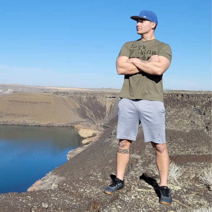 A trainer standing on the top of a hike.