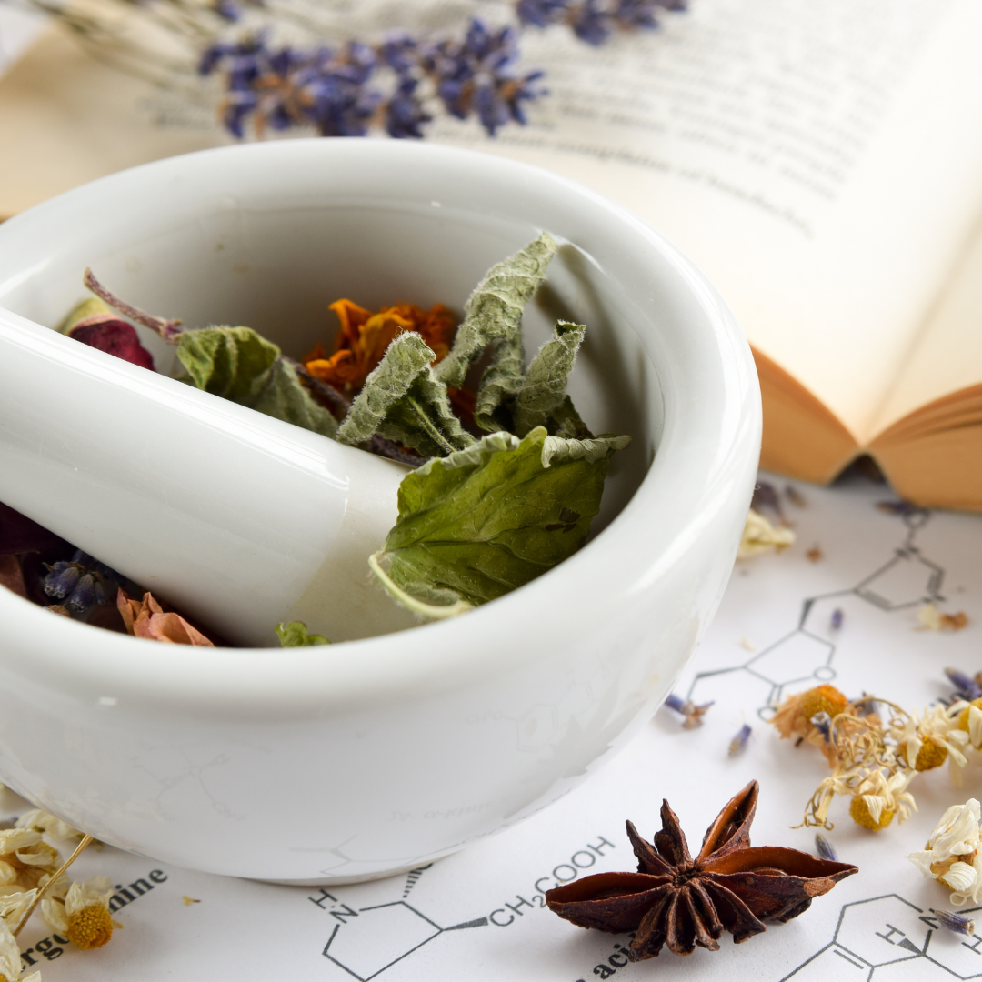 Tea leaves in a bowl with a book in the background