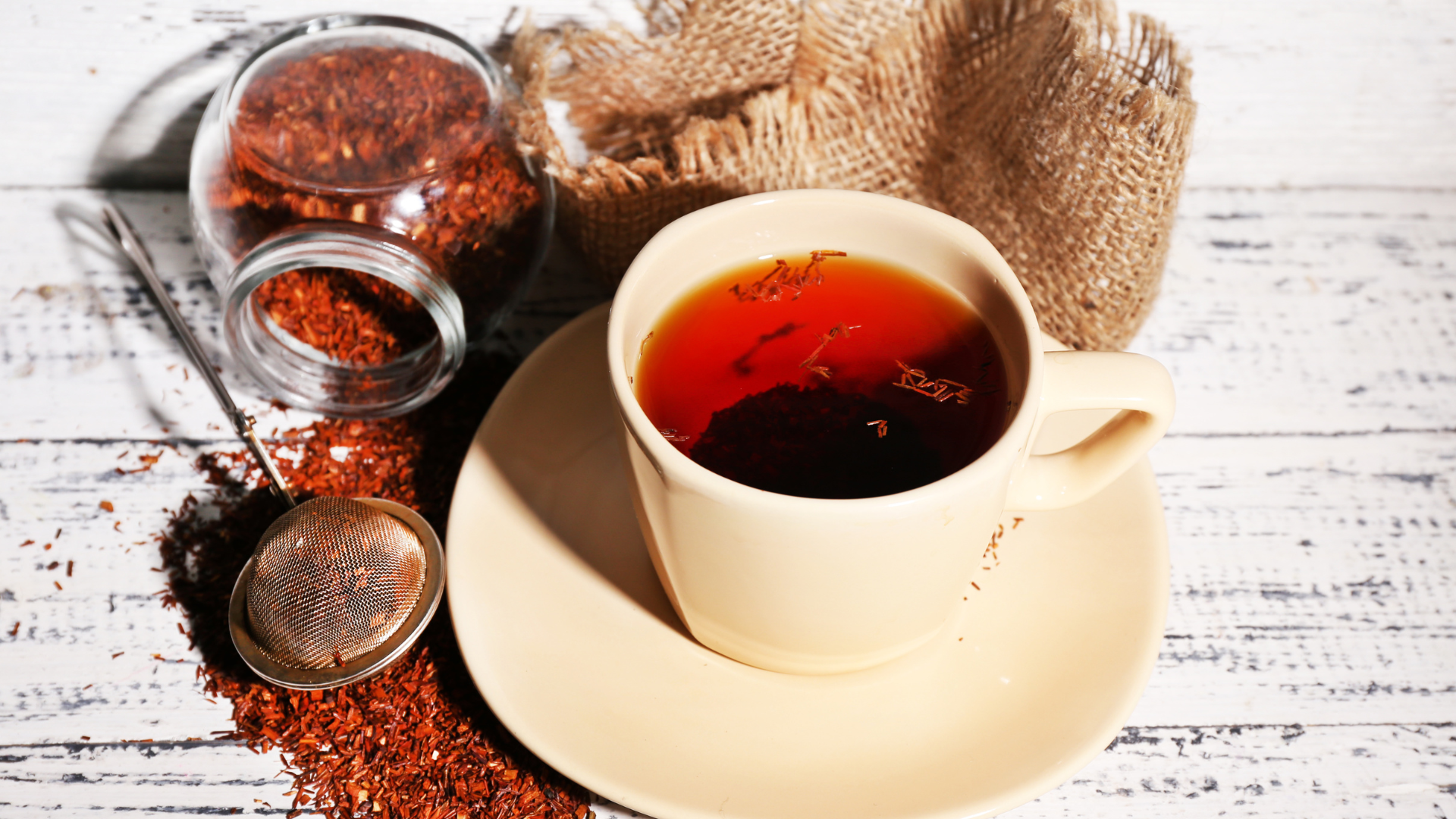 A fresh cup of Rooibos tea with the ingredients surrounding it. 