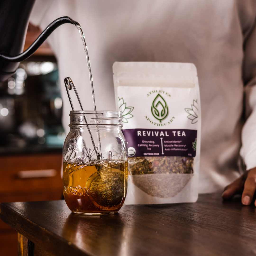 Tea being poured into a jar with a package of 'Revival Tea' in the background.